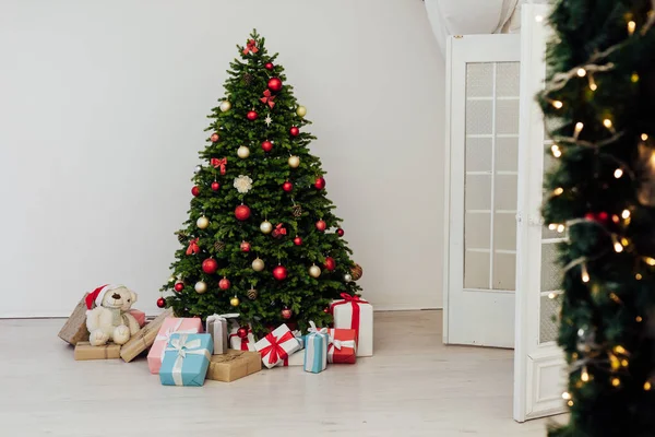 Beau sapin de Noël avec des cadeaux décor nouvel an et terrier chambre blanche — Photo