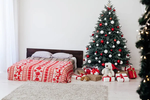 Υπνοδωμάτιο με διακόσμηση κρεβάτι το νέο έτος και όμορφο χριστουγεννιάτικο δέντρο με δώρα — Φωτογραφία Αρχείου