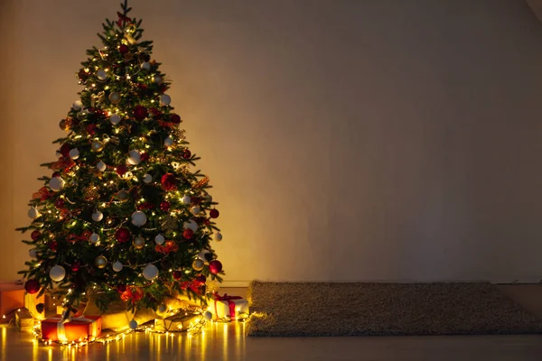 Luces de noche guirnalda árbol de Navidad con regalos decoración interior año nuevo — Foto de Stock