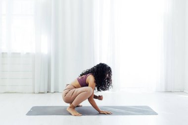 Yoga sınıfındaki esmer kadın jimnastik sporu yapıyor.