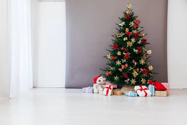 Albero di Natale decorato con regali di Capodanno in una stanza con una finestra — Foto Stock