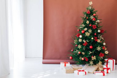 Yeni yıl süslenmiş Noel ağacı evde hediyelerle dolu.