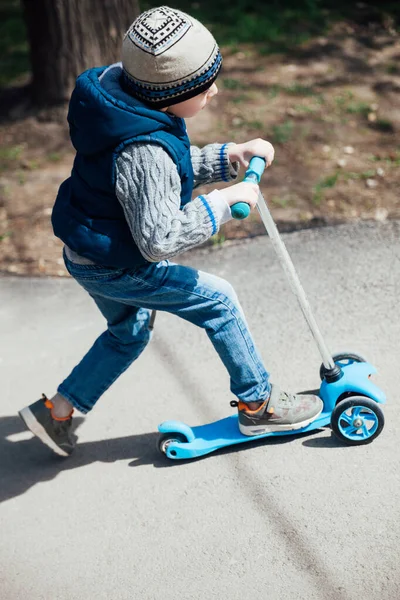 Маленький хлопчик катається на скутері на дорогах на дитячому майданчику — стокове фото