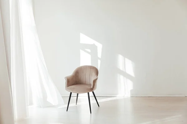 Один бежевый стул в интерьере пустой белой комнаты с окном — стоковое фото