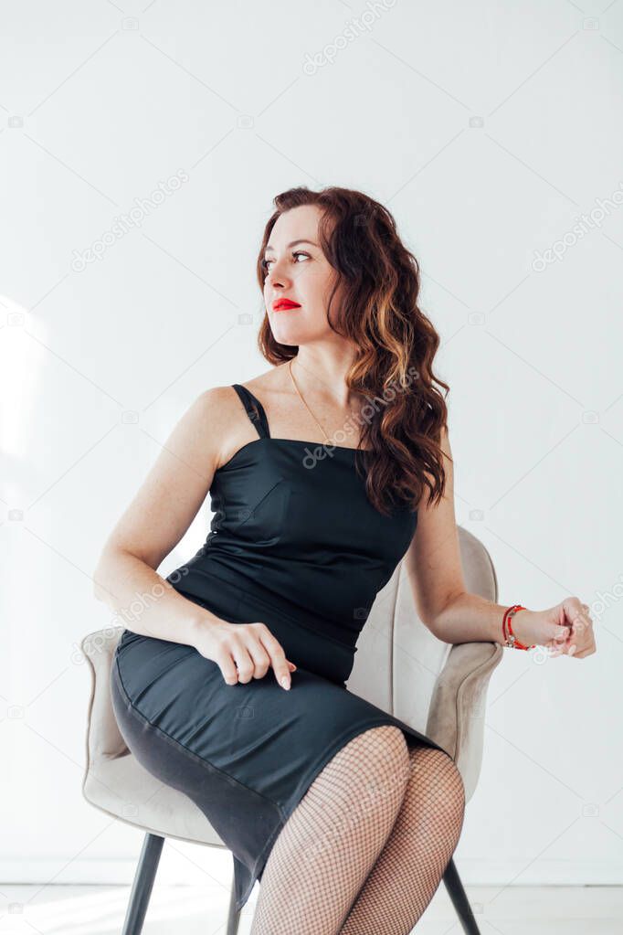 Portrait of a beautiful brunette woman in a black evening dress