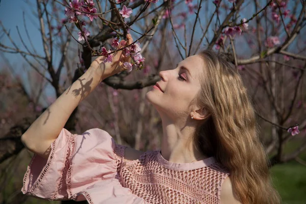 Mulher loira bonita em vestido rosa em flor primavera jardim verde — Fotografia de Stock