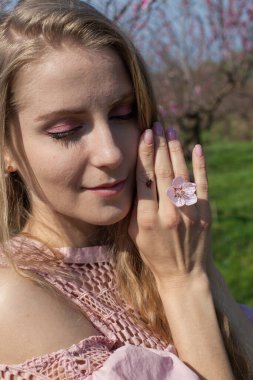 Baharda güzel bir kadının elinde böceğin uğur böceği