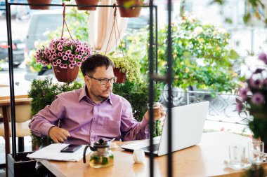 Lokantada tekerlekli sandalyede yemek yiyen engelli adam.