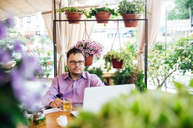 Lokantada tekerlekli sandalyede yemek yiyen engelli adam.