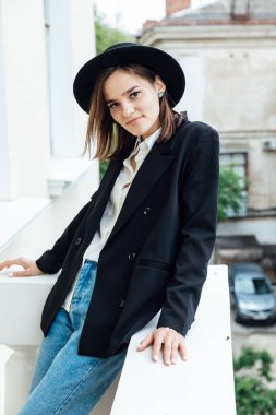 Tarlaları ve ceketi olan siyah şapkalı güzel bir kadın.