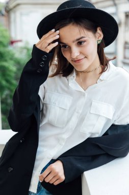 Tarlaları ve ceketi olan siyah şapkalı güzel bir kadın.