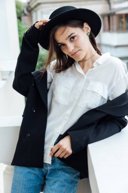 Tarlaları ve ceketi olan siyah şapkalı güzel bir kadın.