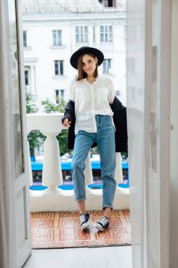 Tarlaları ve ceketi olan siyah şapkalı güzel bir kadın.