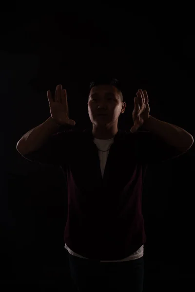 Asian man dances to music in the dark on a black background — Stock Photo, Image