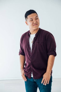 Beyaz odadaki yakışıklı Asyalı bir adamın portresi.