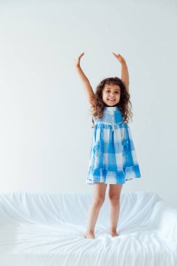 Mavi elbiseli küçük kız beyaz koltukta