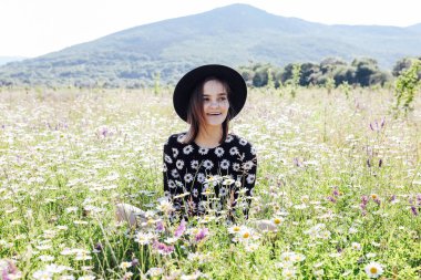 Papatya tarlasında giyinmiş güzel bir kadın