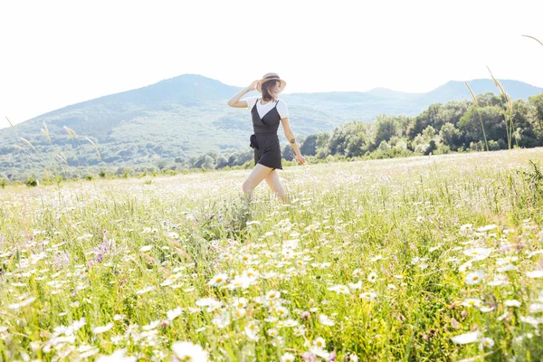 Bella giovane donna felice corre sul campo di margherite — Foto Stock