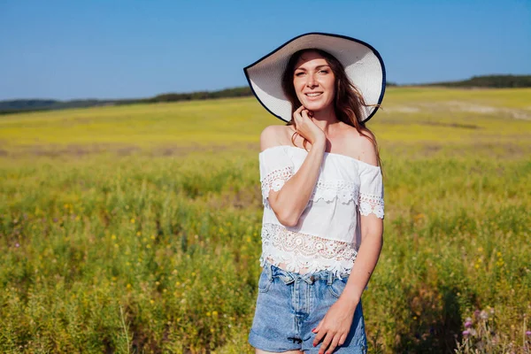 Retrato de uma mulher bonita em um chapéu em um campo na natureza — Fotografia de Stock
