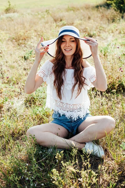 Retrato de uma mulher bonita em um chapéu em um campo na natureza — Fotografia de Stock