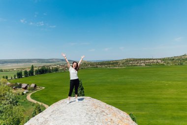 Güzel bir kadın uçurumun kenarında durmuş yolculuğun doğasına bakıyor.