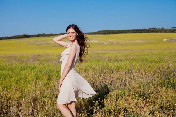 Doğada bir tarlada yürüyen elbiseli güzel bir kadın. — Stok fotoğraf