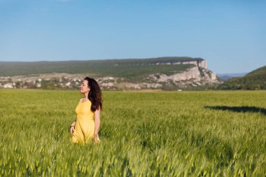 Yeşil buğday tarlasında hasat öncesi bir kadın.
