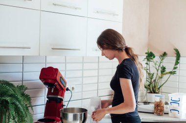 Bir kadın mutfakta tatlı kekler pişiriyor.