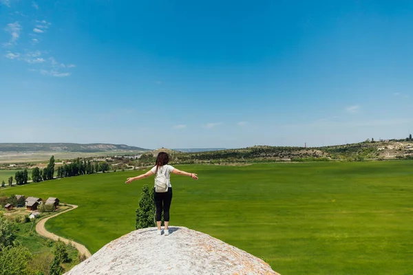 Beautiful woman standing on a cliff looking at the nature of the journey — Stock Photo, Image