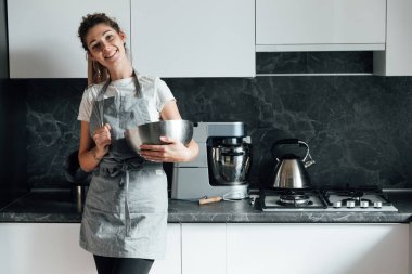 Güzel kadın ev hanımı mutfakta lezzetli yemekler pişirir.