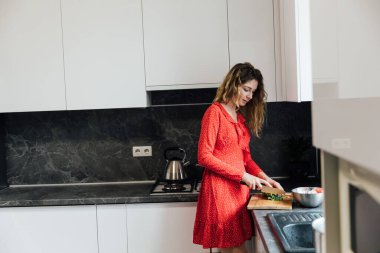 Güzel kadın ev hanımı mutfakta sebze salatası hazırlıyor.