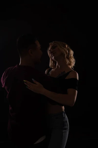 Un hombre y una mujer bailan juntos al son de la música en la oscuridad —  Fotos de Stock