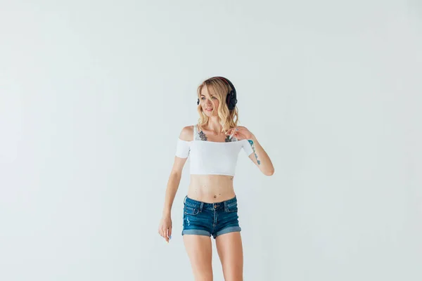 Mujer rubia bailando música en auriculares en el entrenamiento —  Fotos de Stock