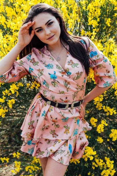 Schöne brünette Frau in einem Kleid mit Blumen Porträt — Stockfoto