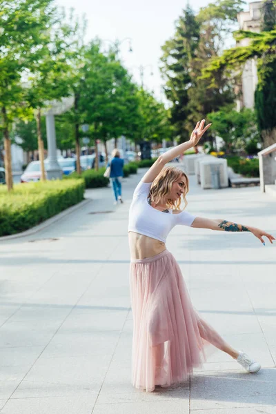 Bela mulher loira dançando a música na rua sozinha — Fotografia de Stock