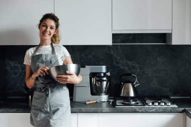 Güzel kadın ev hanımı mutfakta yemek pişirir.