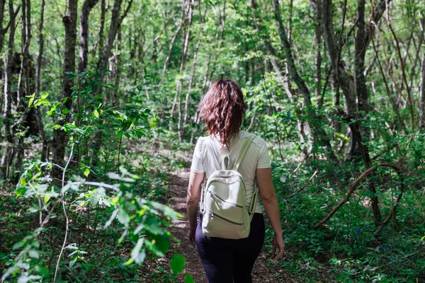 Mulher andando pela estrada em uma caminhada de viagem de floresta verde — Fotografia de Stock