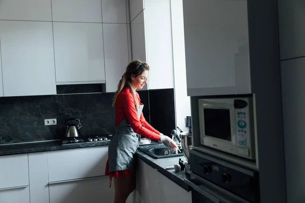 Donna casalinga lava i piatti sporchi in cucina — Foto Stock