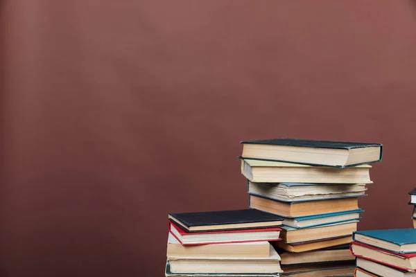 Pilas de libros para el entrenamiento de la biblioteca universitaria Fondo marrón — Foto de Stock