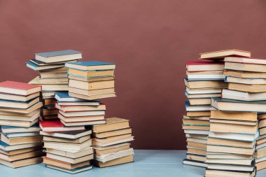 Üniversite kütüphanesinde kahverengi arkaplan bilgisi öğretmek için kitap yığınları