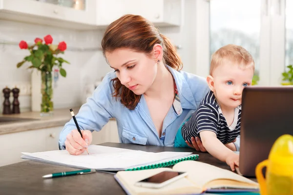 Young mother working with her baby — Stock Photo, Image