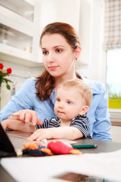 Young mother working with her baby — Stock Photo, Image