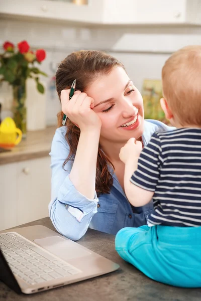 Young mother working with her baby — Stock Photo, Image