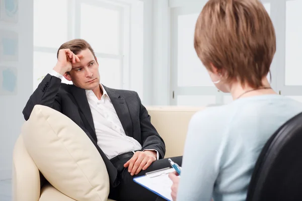 Hombre deprimido hablando con psicólogo — Foto de Stock