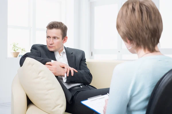 Opprørt mann snakker med psykolog – stockfoto