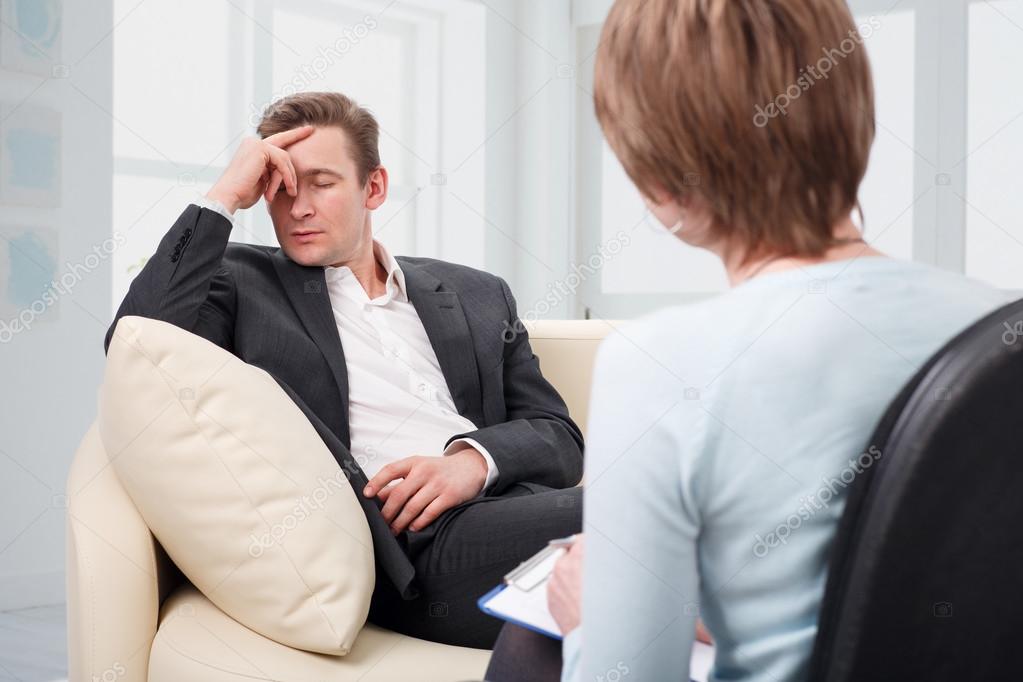 Depressed man talking with psychologist