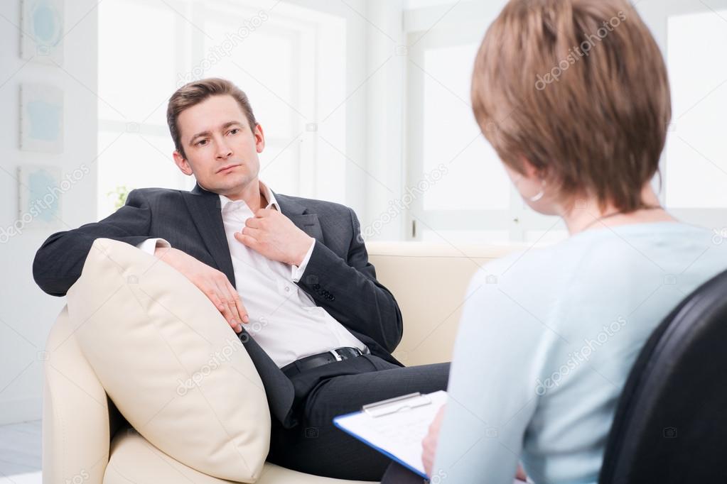 Depressed man talking with psychologist