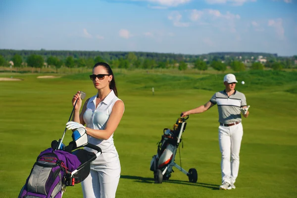 Jeunes femmes et hommes jouant au golf — Photo