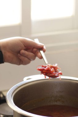 Yemek ve yemek konsepti. Adam ocakta çorba pişiriyor.