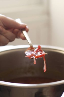 Kadın eli kâseye sos döküyor.